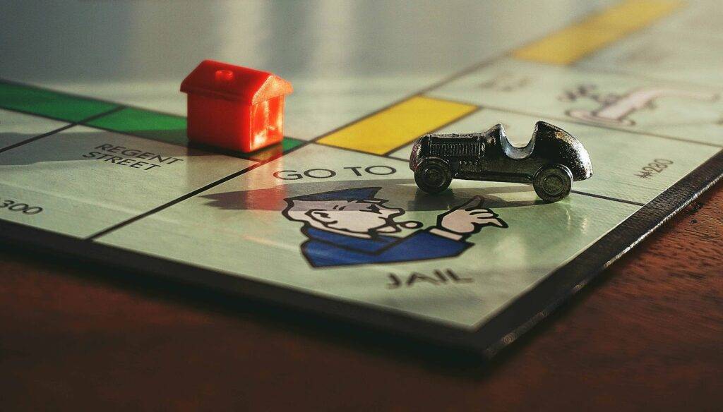 A house and car on a monopoly board